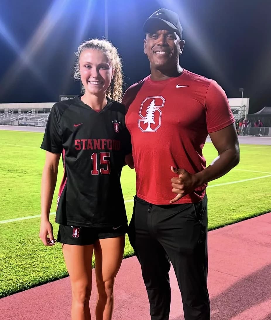 Coach Daniel on the soccer field with a college player