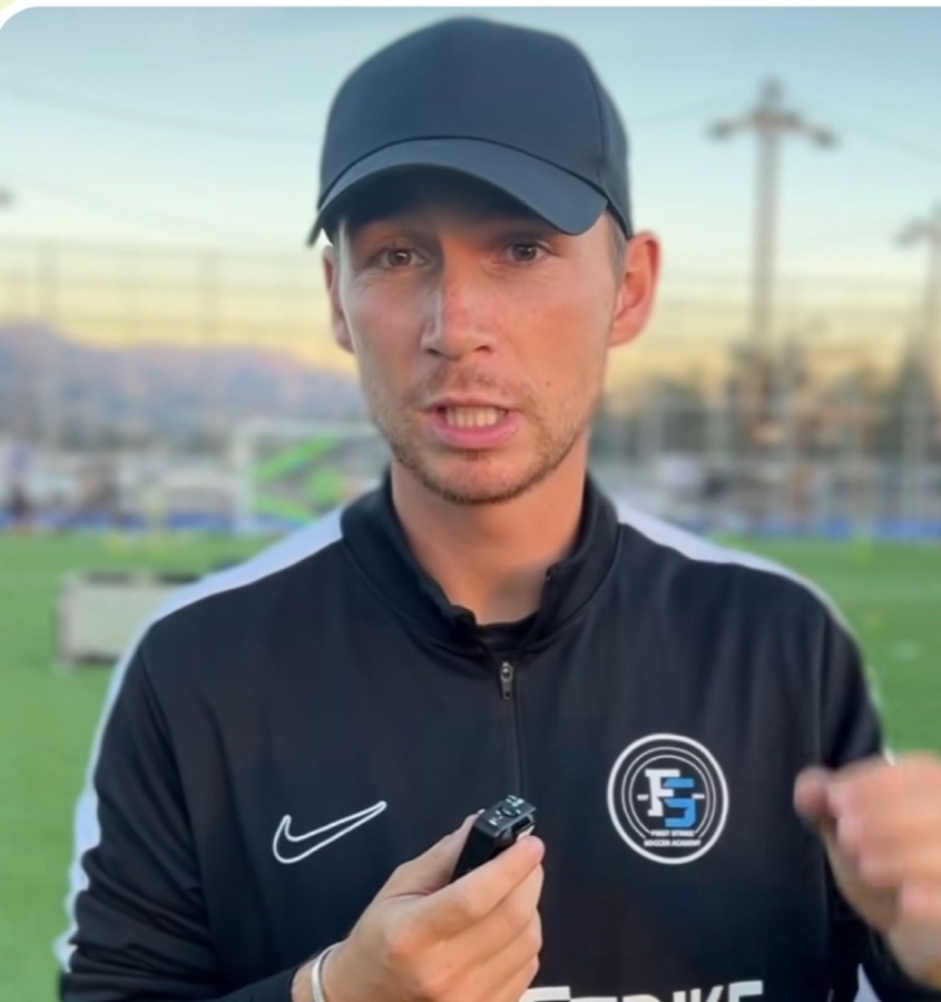 Soccer coach explaining a practice drill on the training pitch
